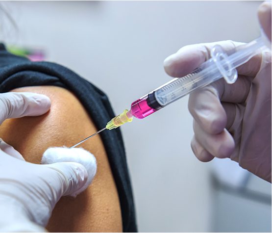 closeup of healthcare worker giving a vaccine to senior patient